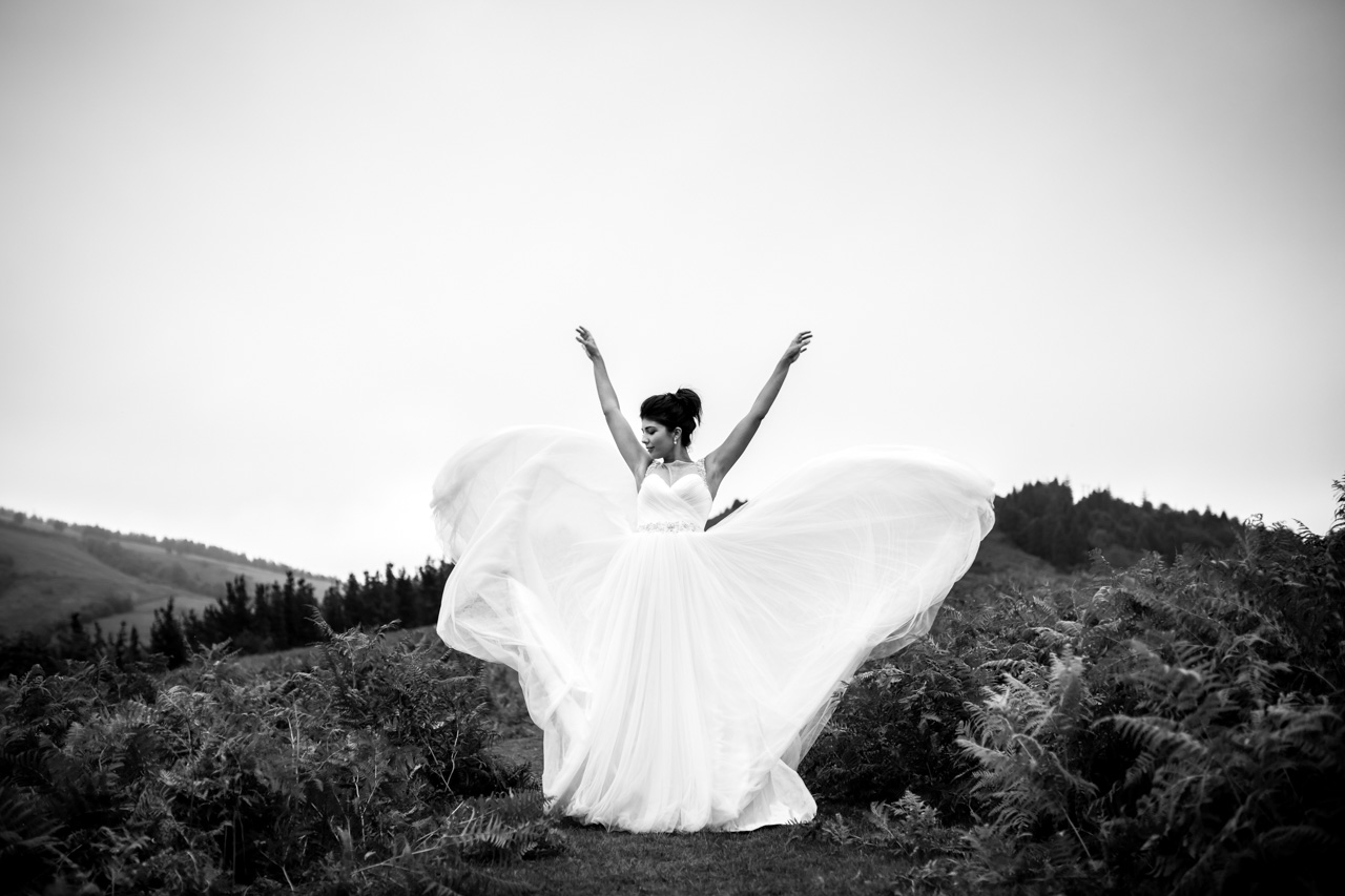 la novia lanza la cola de sus vestido en una postboda en peñas de aia