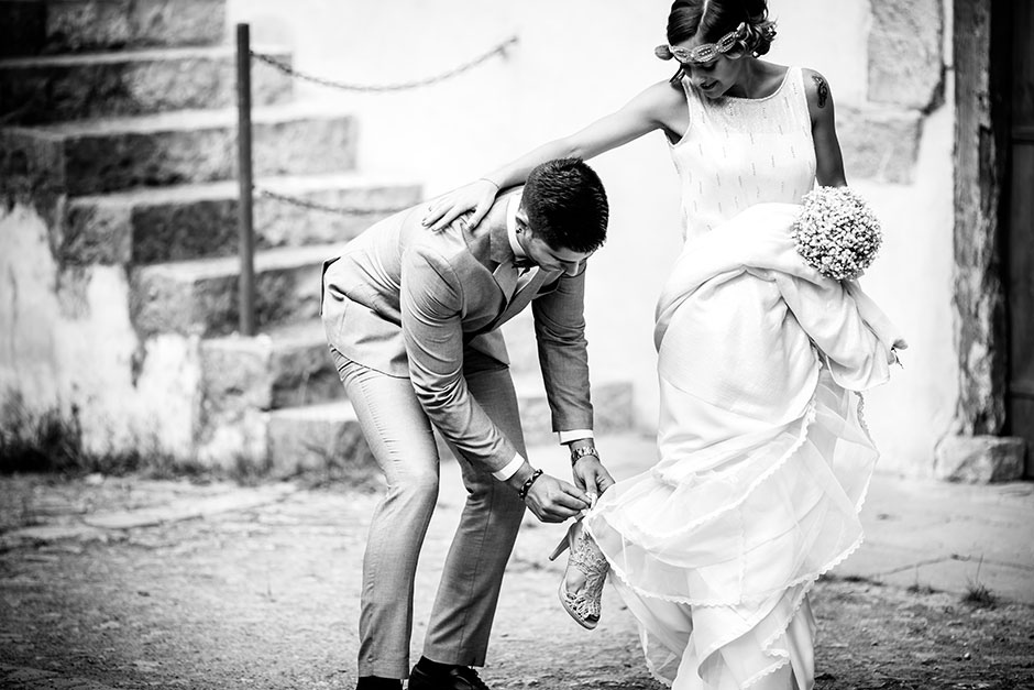 novio atandole el zapato a su novia en un reportaje de boda en irun