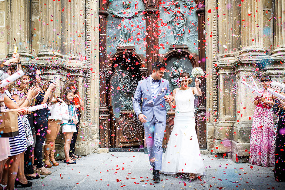 salida de una iglesia con mucho arroz y petalos en un reportaje de boda fotografo de bodas en guipuzcoa