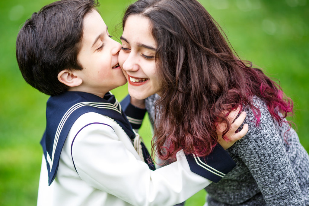 beso de un niño vestido de comunión a su hermana en un reportaje de comunión en hondarribia