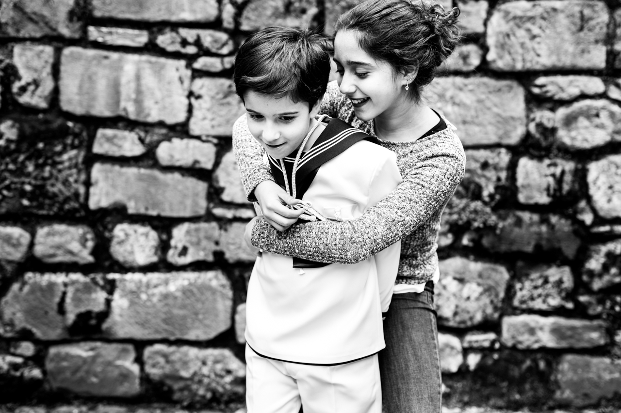 hermana abrazando a su hermano vestido de comunión en un reportaje de comunión