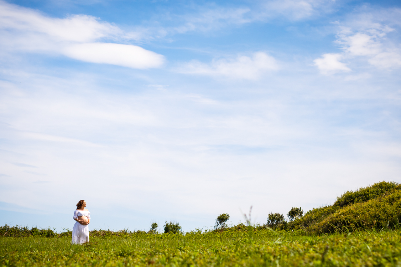 retrato de una mujer embarazada en una ladera verde fotografos