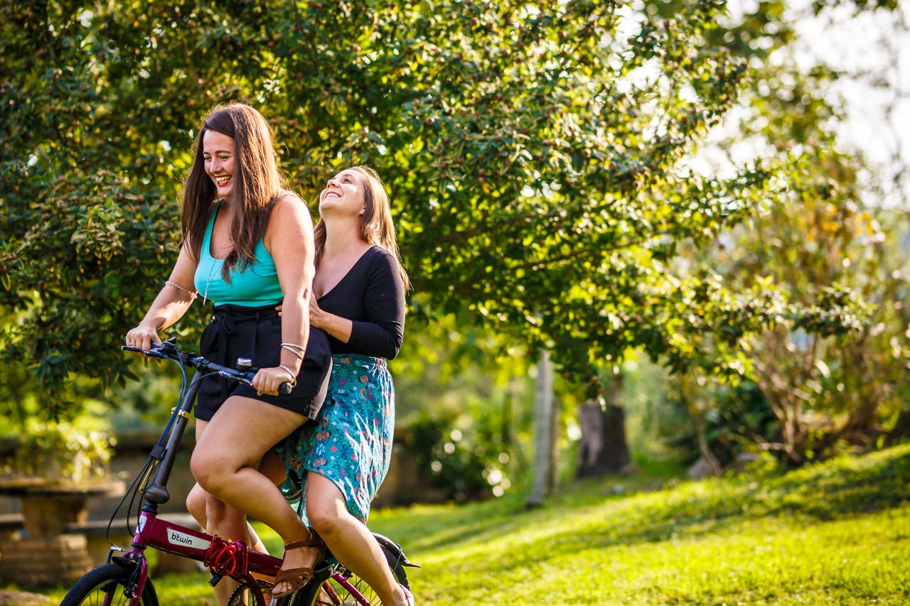 las novias se ríen mientras andan en bici en una preboda en oiartzun