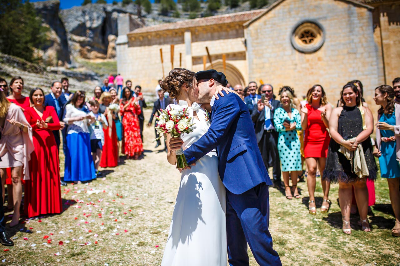 los novios se besan delante de todos los invitados al salir de la iglesia en una boda en soria