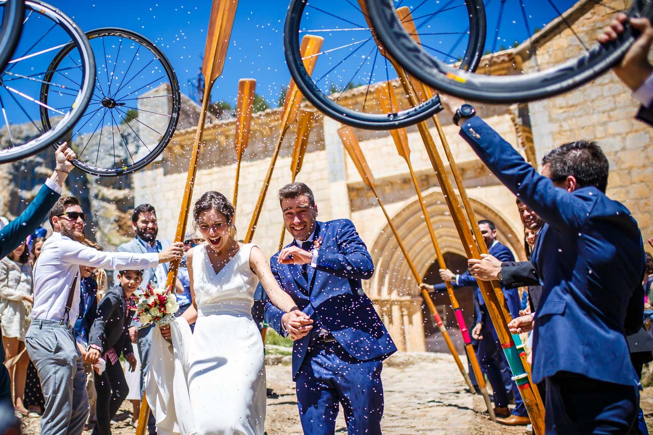 los novios pasan por un arco hecho con remos y ruedas de bici en una boda en soria